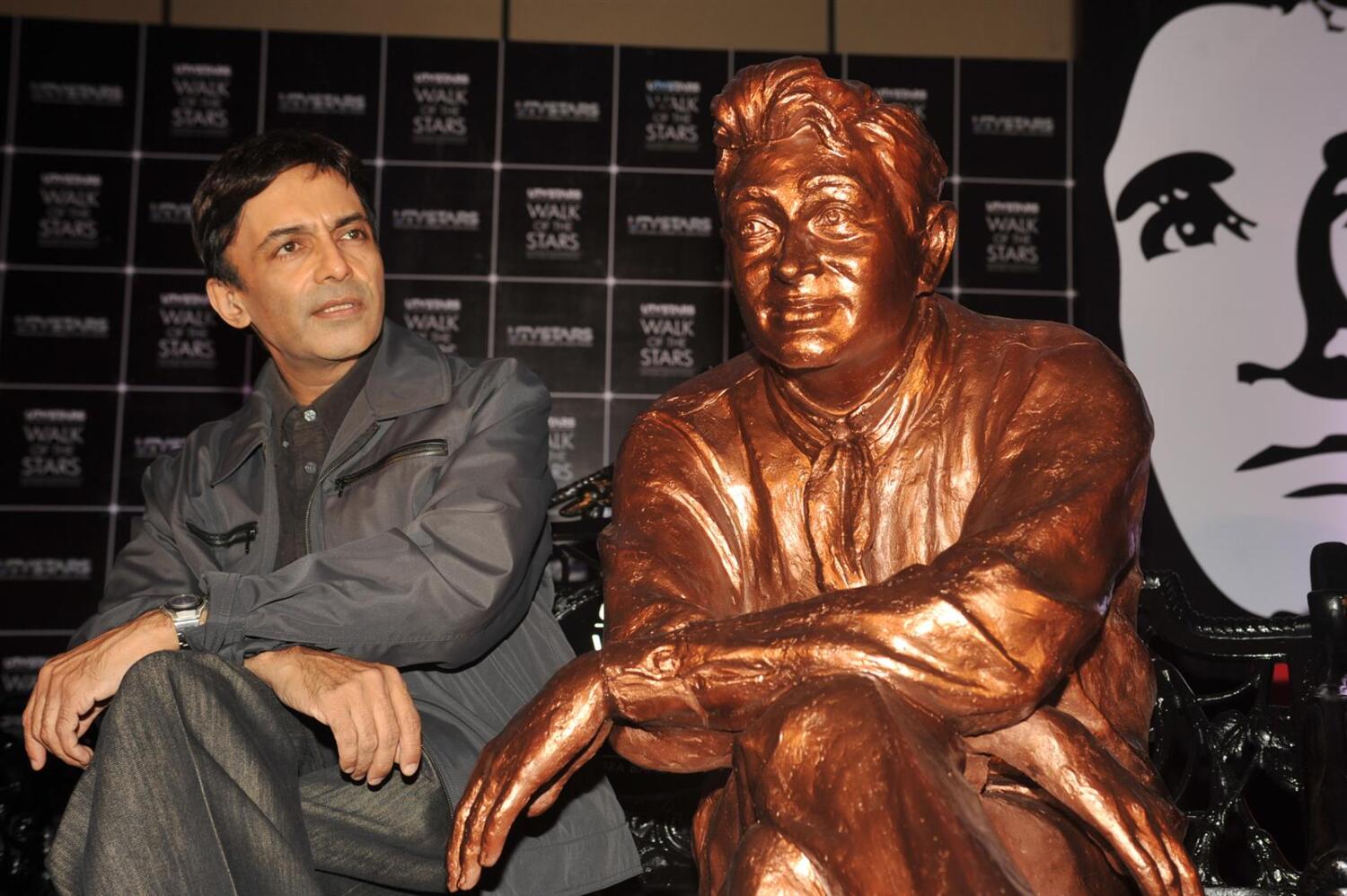 Dev Anand s son Suneil Anand posing with the brass statue of his late